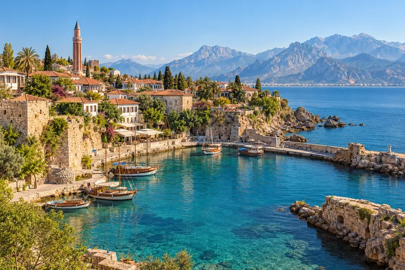 The old Roman harbor of Kaleici in Antalya with the fluted Yivli Minaret and the Taurus Mountains beyond