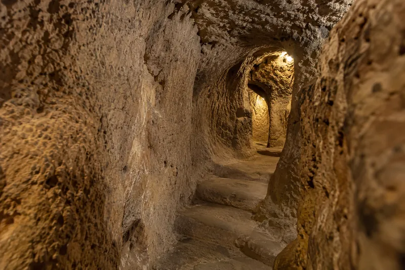 A lamplit carved tunnel in the Kaymakli underground city in Cappadocia