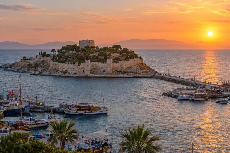Pigeon Island castle and Kusadasi harbor at sunset on the Aegean coast