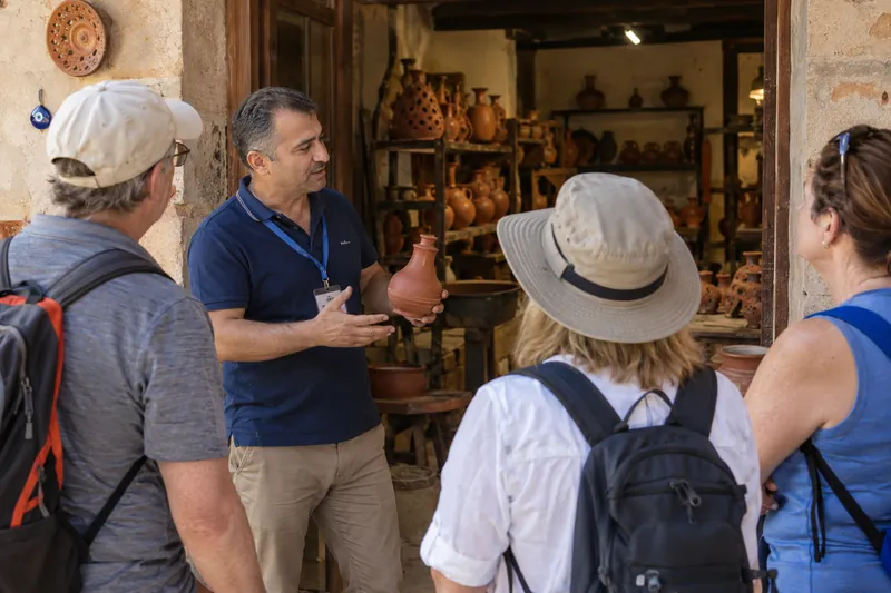 A private guide showing travelers traditional red clay pottery at a workshop in Avanos