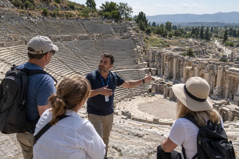 A private guide telling the story of Acts 19 to travelers in the Great Theatre of Ephesus