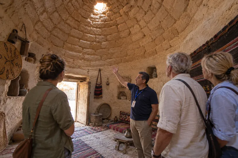 A private guide explaining the corbelled dome inside a Harran beehive house