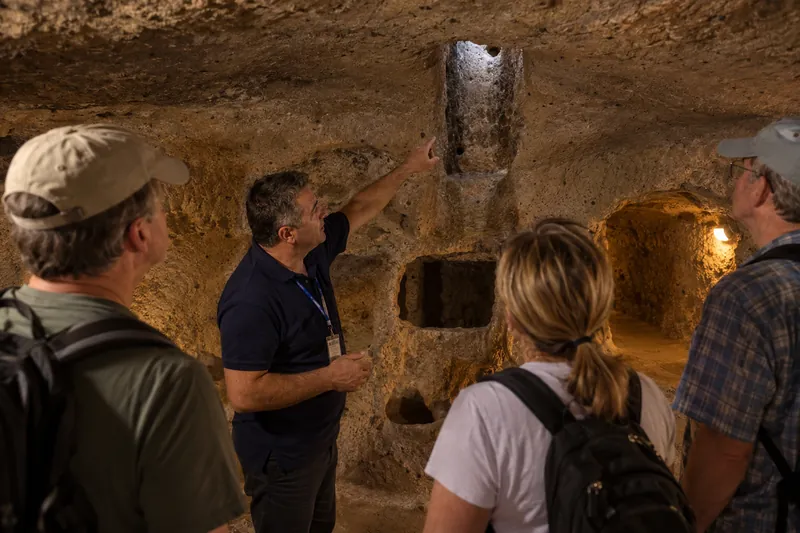 A private guide pointing out a ventilation shaft in the Ozkonak underground city