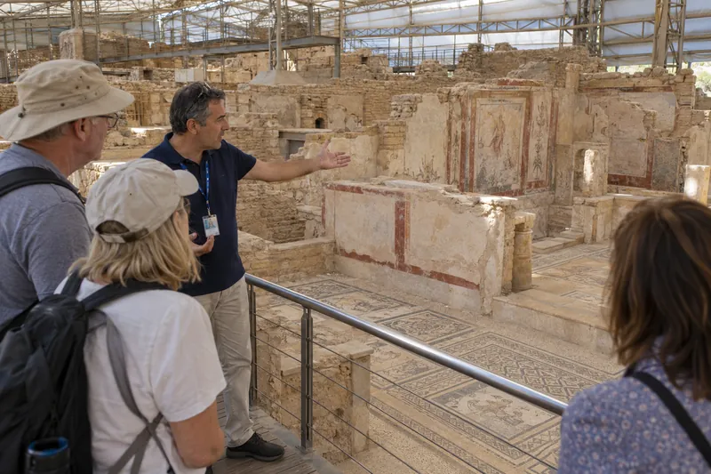 A guide showing travelers the frescoes of the Terrace Houses in Ephesus
