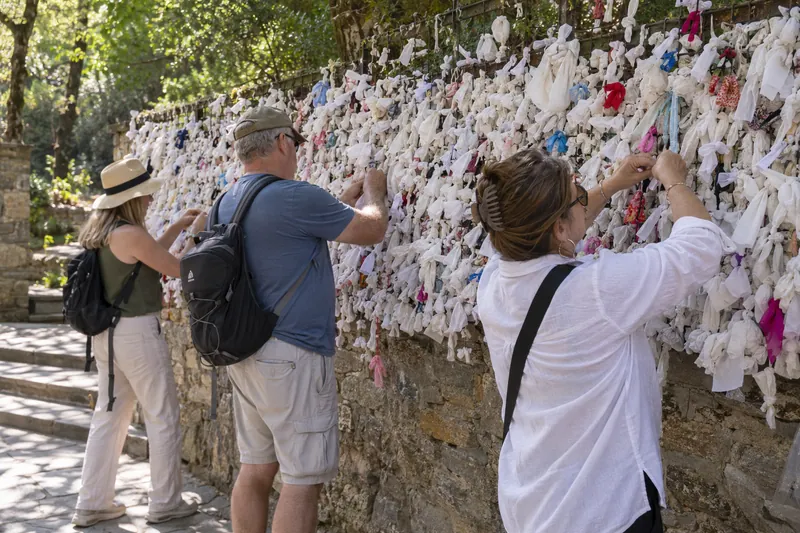 Travelers tying their prayers to the wishing wall at the House of the Virgin Mary near Ephesus